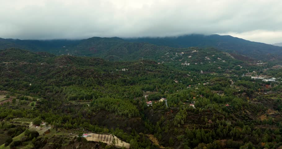 Drone aerial view of Troodos Mountains covered with low clouds and forested hills in Cyprus