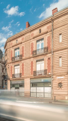 Panorama showing historic brick facades at Rue du Languedoc and Theodore Ozenne intersection timelapse in Toulouse, France. Shops, cafes, road traffic near Carmes metro station in vibrant city center