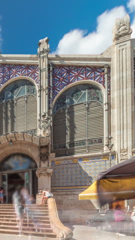 Valencia Central Market timelapse hyperlapse. Historic public market with stunning architecture, stained glass, dome and tile details. Located in Market Square near Santos Juanes Church. Spain