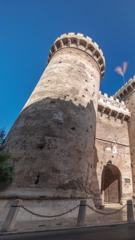 Towers of Quart timelapse hyperlapse in Valencia, Spain. Historical medieval gate, part of the ancient city walls. Popular landmark with a rich cultural heritage. Blue sky and street traffic scene.