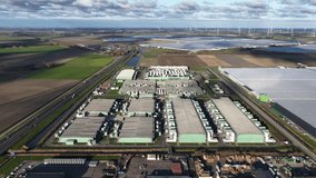 Aerial view of AI Data Center with rows of servers, solar panels, and wind turbines in the rural landscape, Middenmeer, Netherlands. - Powered by Shutterstock - Get 15% off with code: PIKWIZARD15