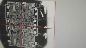 Microscope close-up of an integrated circuit die with red crosshair overlay, revealing intricate silicon microchip layout and probe contacts during semiconductor inspection - Powered by Shutterstock - Get 15% off with code: PIKWIZARD15
