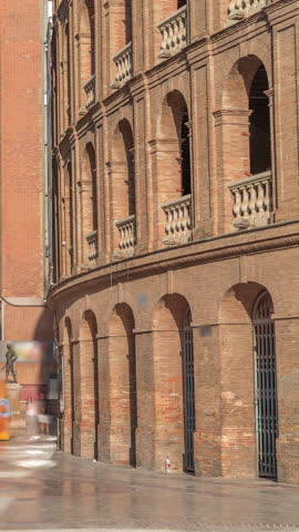 Timelapse of the Bullring of Valencia (Plaza de Bous) and Bullfighting Museum, near Nord station. People walking around the historic amphitheater with a blue sky backdrop. Valencia, Spain.