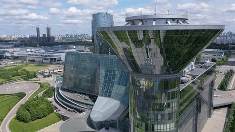 Drone Descending along Modern Office Complex Exterior