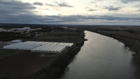 Aerial Descending Drone Shot Over Greenhouses and Irrigated River in Winter - Powered by Shutterstock - Get 15% off with code: PIKWIZARD15