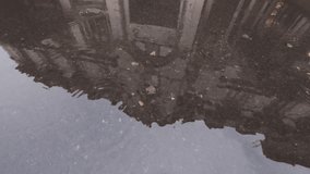 An old house is reflected in puddle on asphalt, reflections of peoples with umbrellas pass by house, drops of rain fall on water, washing out their mirroring. - Powered by Shutterstock - Get 15% off with code: PIKWIZARD15
