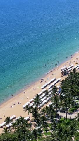View of the azure sea and the central beach of Nha Trang from the window of a high-rise building. Top view of the tropical coast of Vietnam. Resort on the coast of the South China Sea in the afternoon. 4К