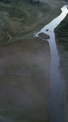 Aerial View of Two Rivers Merging in British Columbia, Canada, Through Morning Mist