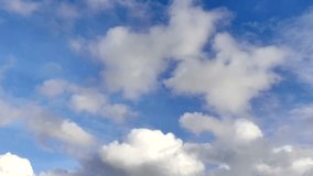 Soft white cumulus clouds drifting slowly across a bright and clear blue sky. This high quality nature background captures a peaceful and serene atmosphere. Perfect for projects themed around weather, backgrounds or environmental beauty - Powered by Shutterstock - Get 15% off with code: PIKWIZARD15