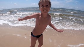 Slow Motion Video of a Happy Boy Running and Dancing on a Sea Shore Before Swimming in Shallow Waves on a Beach - Powered by Shutterstock - Get 15% off with code: PIKWIZARD15