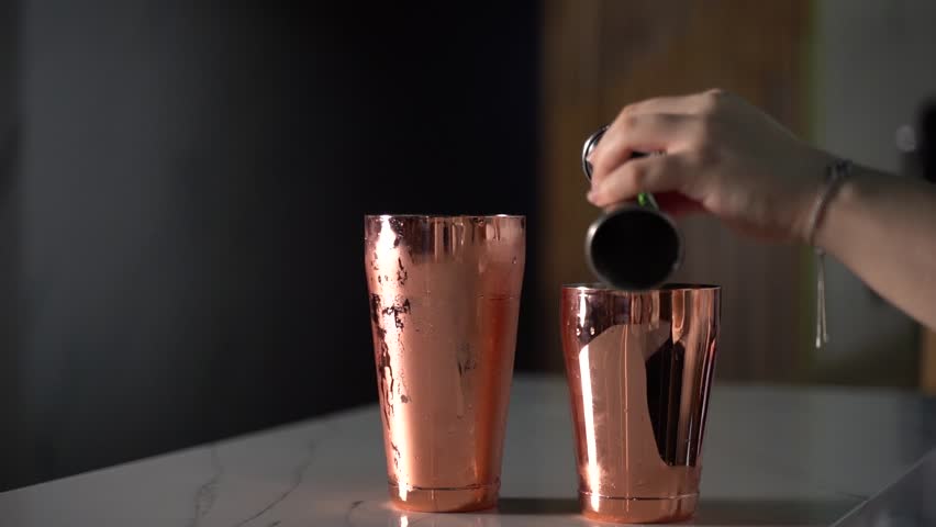 bartender preparing a cocktail with orange juice