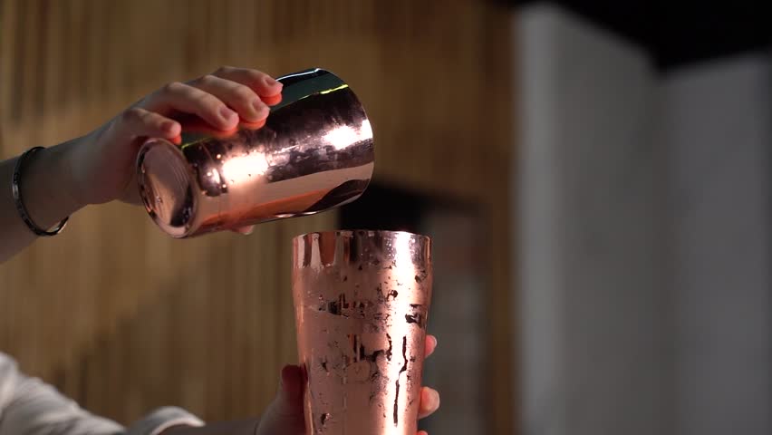 bartender preparing a cocktail with orange juice