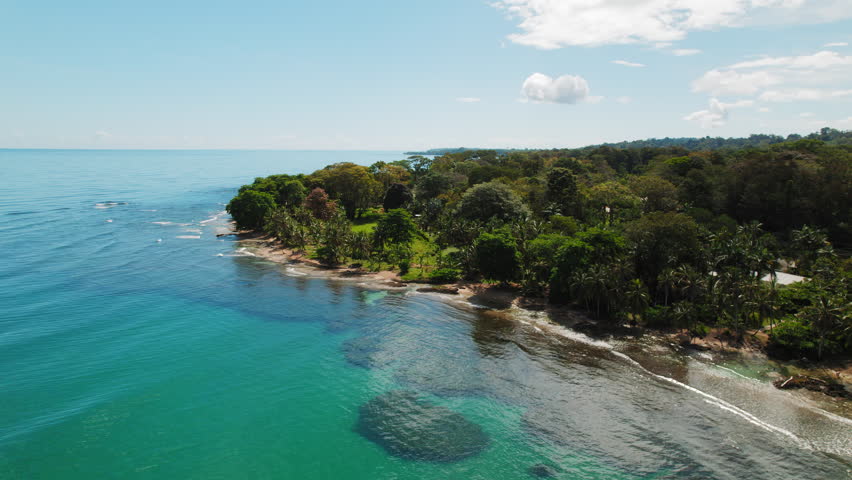 Costa Rica coastline with dense green forest under bright sunny skies