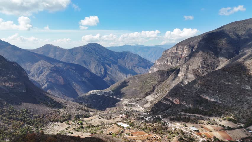 Ravine with village surrounded by large mountains aerial view