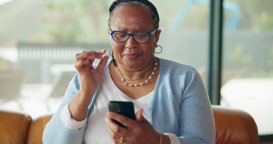 Senior woman, glasses and phone for reading, scam message or fake news on sofa in living room. Annoyed, notification and elderly african person with technology, online fraud and doubt in home