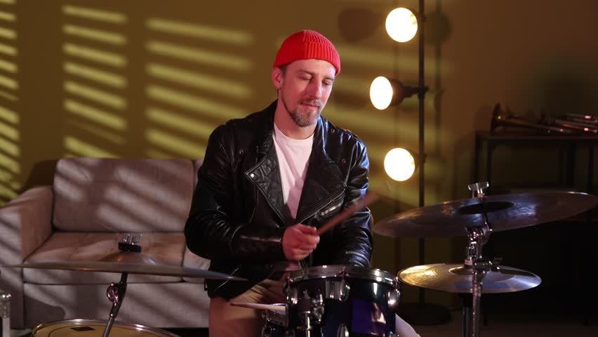 Man playing drums with drumsticks in studio