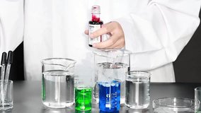A scientist in a white lab coat adds red liquid to beakers creating smoke. - Powered by Shutterstock - Get 15% off with code: PIKWIZARD15