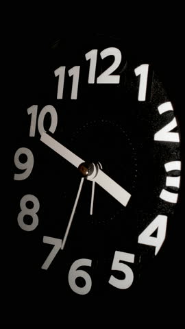 Tme lapse video of a clock time passing over a day to night on black background.