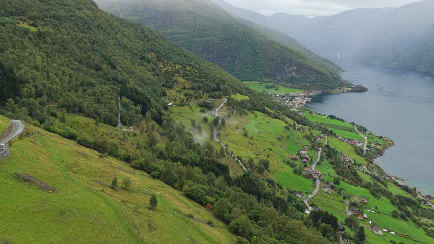 Norwegian fjord road with camper on tight mountain route near Aurlandsfjord, aerial view