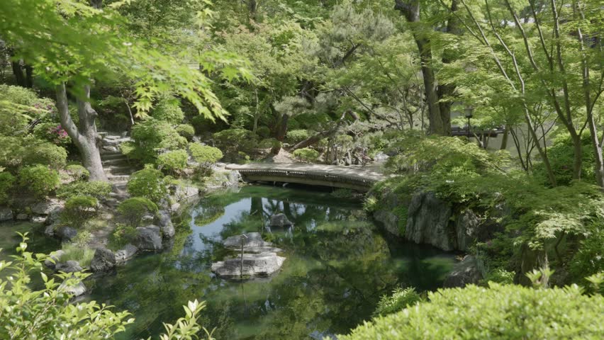 Stone bridge and a pond in a japanese garden on a sunny summer day at Wakayama Castle Park, Japan.