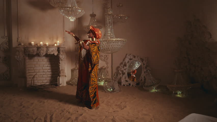 Beautiful african woman dancing on sand in amazing studio, soul of desert. Traditional african gown and ethnic music, unique dance performance, save heritage and culture of Africa, full-length shot