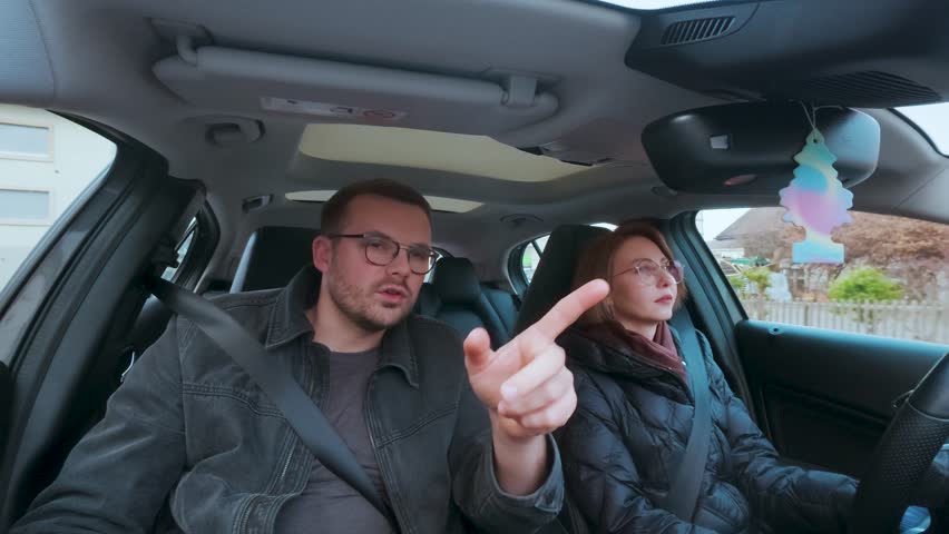 Man in passenger seat pointing and explaining directions to the driver — concept of human navigation, teamwork, or learning to drive.
