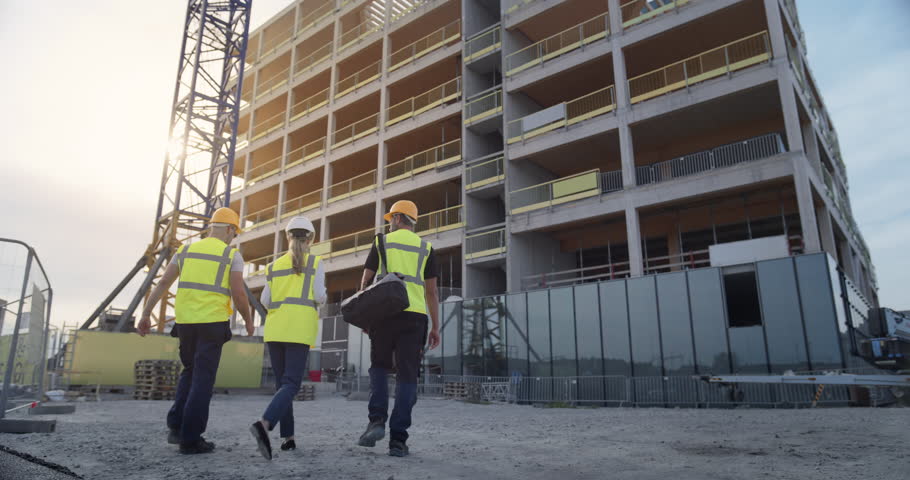 Construction Engineers Walk to a High Rise While Augmented Reality Light Lines Graphics Build the Structure, Projecting Digital Building Data, Smart Architecture, Modern Construction Digitalization