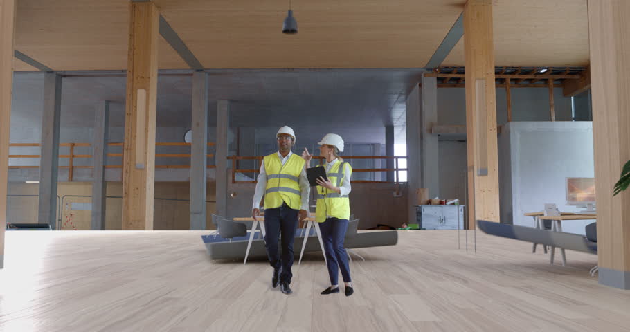 Engineer and Architect Walk Through a Office Interior as Augmented Reality Overlays Transform Under Construction Floor Into a 3D Workspace, Visualizing Interior Design with Special Effects