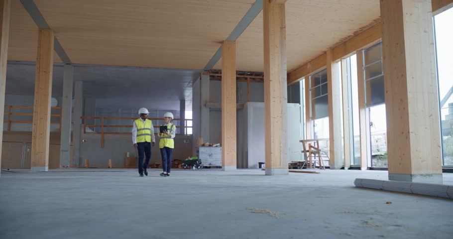 Engineer and Engineer Walk Through a Building with Tablet they Activate Holographic Overlays taht Reveal Hvac Routes, Structural Grids, Bim Data. Digital Construction Planning and Visualization