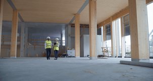 Engineer and Engineer Walk Through a Building with Tablet they Activate Holographic Overlays taht Reveal Hvac Routes, Structural Grids, Bim Data. Digital Construction Planning and Visualization - Powered by Shutterstock - Get 15% off with code: PIKWIZARD15