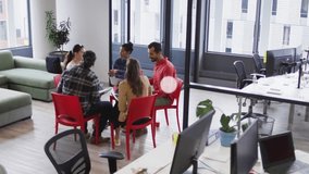 Animation of connected icons over diverse coworkers discussing report in office. Digital composite, multiple exposure, communication, teamwork, business, planning and technology concept. - Powered by Shutterstock - Get 15% off with code: PIKWIZARD15