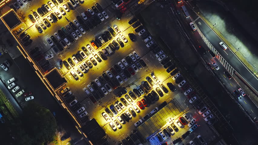Aerial shot of illuminated outdoor car parking lot at night