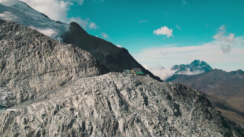 The rocky slopes and sharp ridges of Huayna Potosí. Dramatic, high-altitude terrain of the Andes under a deep blue sky in the Bolivian Altiplano.