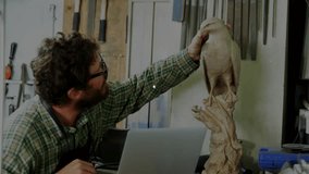 Craftsman rotating bird sculpture while tapping trackpad and initiating data overlay for analytics. Artisan, craftsmanship, digital interface, woodworking, innovation, creativity, technology - Powered by Shutterstock - Get 15% off with code: PIKWIZARD15