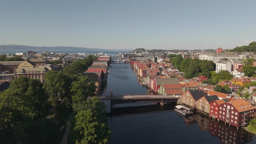 Colorful Riverside Buildings Line the Nidelva River Near the Historic Gamle Bybro (Old Town Bridge) in Trondheim, Norway - Drone Flying Forward