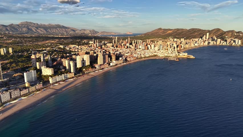 Aerial Morning Golden Light Over Long Beachfront With Gentle Waves, Empty Promenade, Rows Of Apartments,