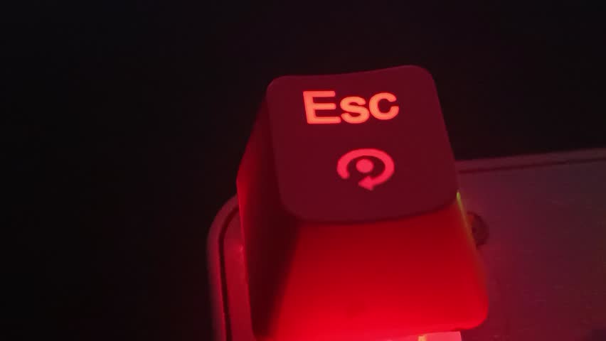Close-up of a glowing red LED mechanical keyboard Esc key with a circular arrow icon. Ideal for gaming, tech, panic, or reset concepts in digital ads, web design, and tech blogs.