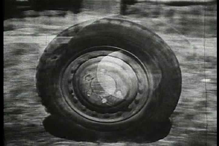 1940s - Tanks roll out of a factory while World War Two rages on the battlefield.