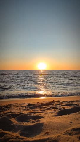 Time-lapse of a dramatic sunset over the Baltic Sea beach. Sun disappearing below the horizo