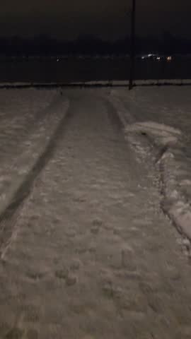 Snowy path to the river at night.