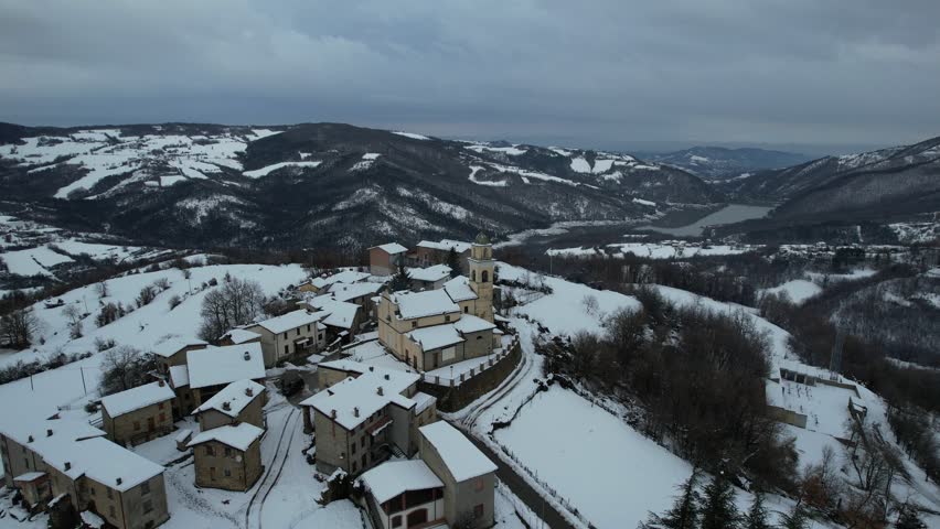 Aerial view of the small Italian village of Vezzolacca, nestled in the snowy Apennine mountains of Piacenza