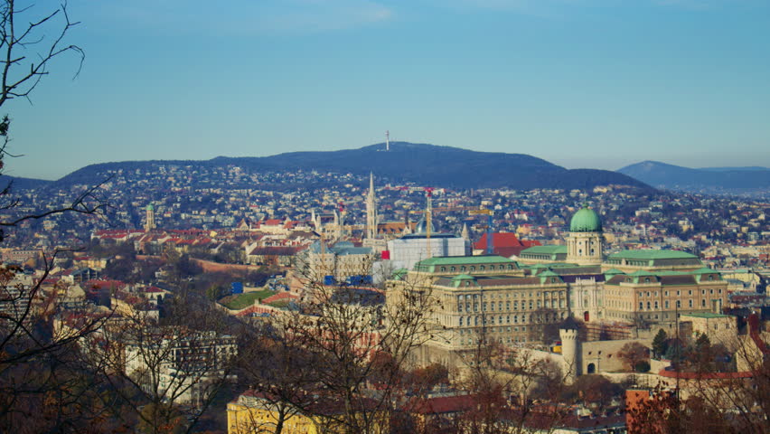 Elevated view overlooking Budapest city with dense buildings, river curves, and expansive urban scenery.