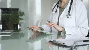 Doctor woman accessing patient data on digital tablet, managing healthcare records in modern medical office. Medicine, health care and science concept - Powered by Shutterstock - Get 15% off with code: PIKWIZARD15