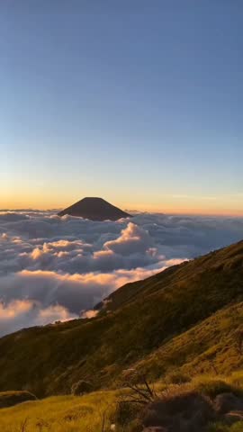 Majestic Mountain Peak Rising Above Sea of Clouds at Sunrise Vertical