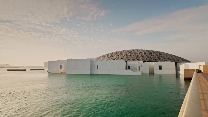 Louvre Abu Dhabi museum with iconic dome and modern architecture, waterfront view, cultural landmark in United Arab Emirates.