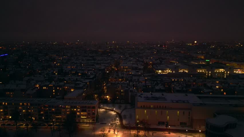 Berlin City rooftops covering in snow at dusk. Majestic aerial view drone