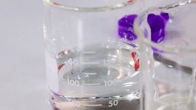 A detailed close-up showing purple dye diffusing and mixing within a clear glass laboratory beaker. - Powered by Shutterstock - Get 15% off with code: PIKWIZARD15