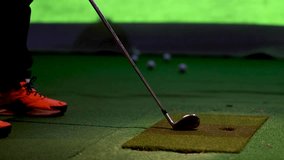 A low angle view of a golfer's orange shoes and club during indoor practice. - Powered by Shutterstock - Get 15% off with code: PIKWIZARD15