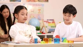 Two elementary students explore colorful geometric blocks during hands-on STEM lesson in bright classroom - Powered by Shutterstock - Get 15% off with code: PIKWIZARD15