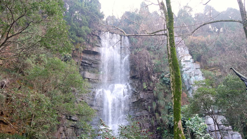 Winter Scenic Waterfall Cascading Through Rocky Gorge In Cold Landscape